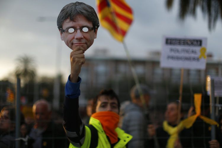 Un manifestante partidario de la independencia de Cataluña sostiene una máscara del exlíder catalán Carles Puigdemont durante una protesta en Barcelona, España, el domingo 25 de marzo de 2018. Foto: Manu Fernández / AP.