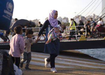 Una mujer siria con sus hijos desembarca de un ferry, en el puerto de El Pireo, cerca de Atenas, el martes 25 de septiembre de 2018. (AP Foto/Petros Giannakouris)
