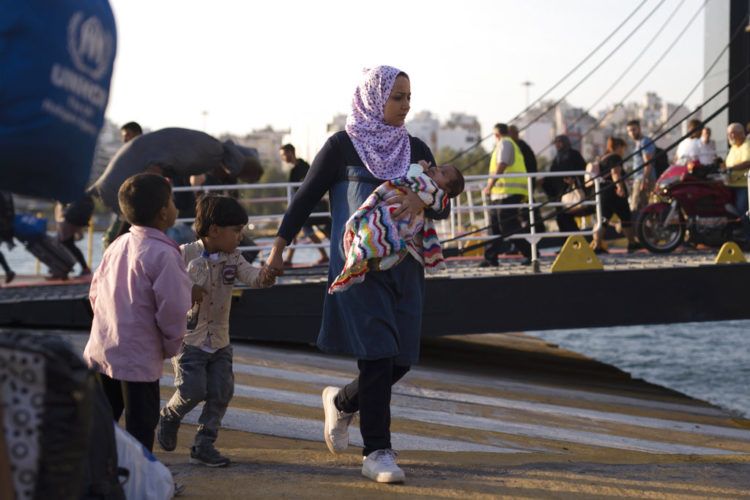 Una mujer siria con sus hijos desembarca de un ferry, en el puerto de El Pireo, cerca de Atenas, el martes 25 de septiembre de 2018. (AP Foto/Petros Giannakouris)
