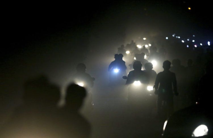 Motociclistas indios atraviesan una espesa nube de smog y polvo en las afueras de Nueva Delhi. Foto: Altaf Qadri / AP.