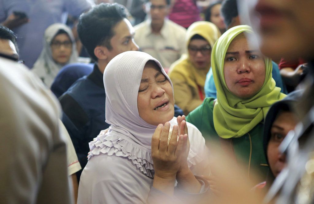 Familiares de los pasajeros del avión accidentado oran mientras esperan más información sobre la aeronave de Lion Air que se estrelló en el mar frente a la Isla Java, en el Aeropuerto Depati Amir de Pangkal Pinang, Indonesia, el lunes 29 de octubre de 2018. Foto: Hadi Sutrisno / AP.
