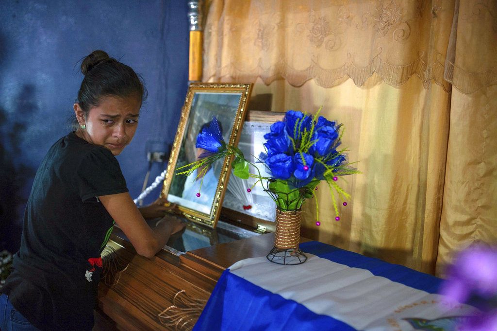 Una joven llora junto al ataúd con los restos de Leyling Chavarría, quien murió cuando la policía y los paramilitares atacaron una barricada establecida por manifestantes antigubernamentales en Jinotega, Nicaragua. Foto: Cristobal Venegas / AP.