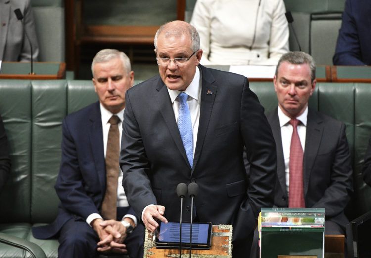 Australian Prime Minister Scott Morrison, center, delivers a formal apology to Australia's victims of child sex abuse in the House of Representatives at Parliament House in Canberra, Monday, Oct. 22, 2018. His emotional speech delivered in Parliament before hundreds of survivors followed the conclusions of a Royal Commission into Institutional Responses to Child Sexual Abuse, the nations' highest level of inquiry. (Mick Tsikas/AAP Image via AP)
