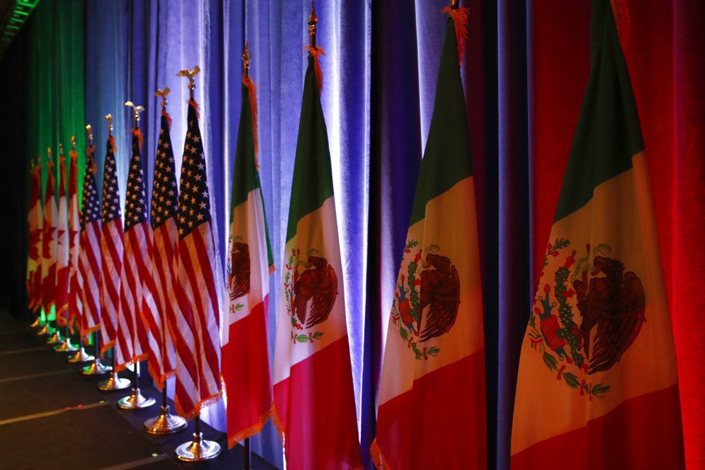 Las banderas de Canadá, EEUU y México sobre un escenario antes de una conferencia de prensa sobre las negociaciones del Tratado de Libre Comercio de América del Norte. Foto: Jacquelyn Martin/AP.