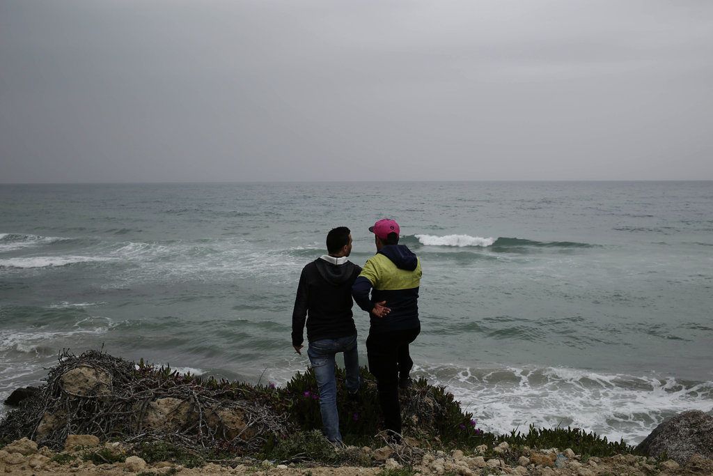 En esta imagen, tomada el 14 de abril de 2018, Ahmed Ayouby, de 32 años (izquierda), y Mounir Aguida, de 30, que quiere salir de Túnez, en la playa desde la que los migrantes parten hacia Italia, en la localidad de Ras Jabal, en Bizerte, Túnez. A finales de agosto de 2018, se subió a una balsa con siete amigos, pero en el último minuto él y otro joven se bajaron de la embarcación. No ha vuelto a saber nada de los demás. (AP Foto/Nariman El-Mofty)