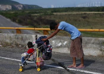Un migrante empuja un carro de bebé por una carretera mientras una caravana formada por miles de centroamericanos sigue su lento avance hacia la frontera con Estados Unidos, entre Niltepec y Juchitan, en el estado de Oaxaca, México, el 30 de octubre de 2018. (AP Foto/Rebecca Blackwell)