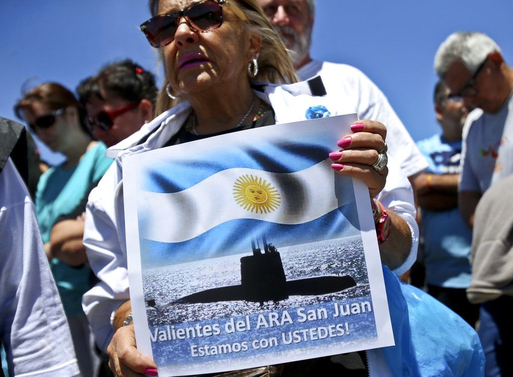 En esta imagen de archivo, tomada el 25 de noviembre de 2017, una mujer sostiene un cartel con el mensaje "Valientes del ARA San Juan, estamos con ustedes", delante de la base naval de la Armada en Mar del Plata, Argentina, donde se reunieron los familiares de los tripulantes desaparecidos en el sumergible. (AP Foto/Esteban Félix, archivo)