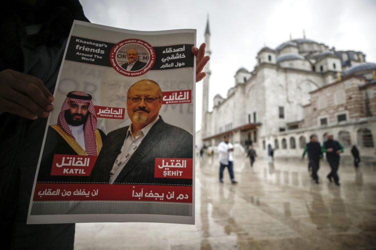 Un hombre sostiene un cartel que muestra imágenes del príncipe heredero saudí Muhammed bin Salman y del periodista Jamal Khashoggi, en el que se describe al príncipe como "asesino" y a Khashoggi como "mártir" durante un momento de oración por Khashoggi, asesinado en el consulado saudí el mes pasado en Estambul, el viernes 16 de noviembre de 2018. Foto: Emrah Gurel / AP.