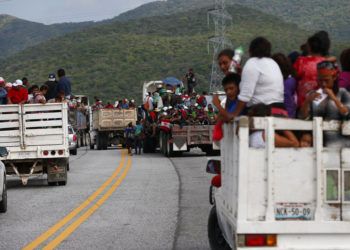Migrantes se suben a las partes traseras de camiones mientras una caravana de miles de centroamericanos que esperan llegar a la frontera de Estados Unidos avanza desde Juchitán en el estado de Oaxaca, México, el jueves 1 de noviembre de 2018.  (AP Foto / Rebecca Blackwell)
