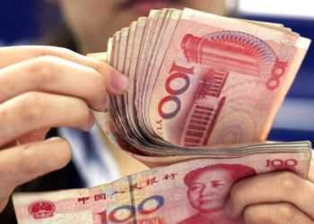 En esta foto del 25 de agosto de 2010, un cajero bancario cuenta billetes de 100 yuan en Shanghái. La moneda china cayó a su nivel más bajo en 22 meses frente al dólar, se informó el jueves 18 de octubre de 2018. (AP Foto/Eugene Hoshiko)