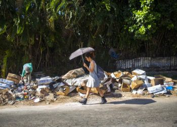 Una mujer camina junto a un montón de basura en el barrio Vedado de La Habana, Cuba. Foto: Desmond Boylan / AP / Archivo.