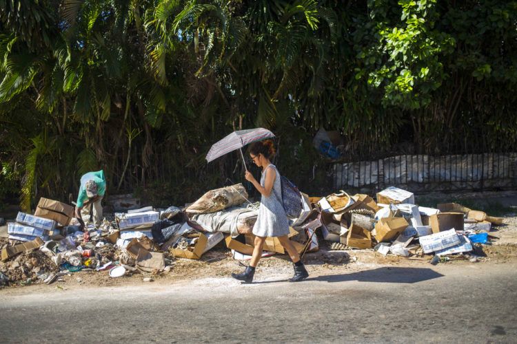 Una mujer camina junto a un montón de basura en el barrio Vedado de La Habana, Cuba. Foto: Desmond Boylan / AP / Archivo.