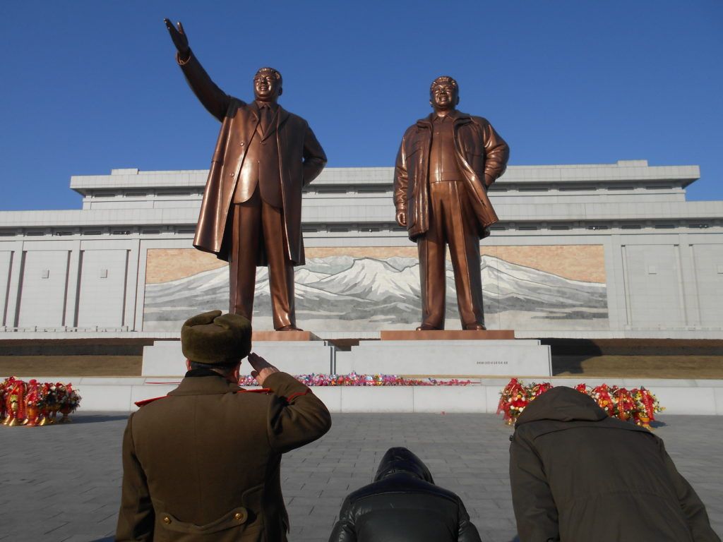 Oficiales norcoreanos rinden homenaje a los "Líderes fundadores" en una plaza de la capital coreana (Foto: Daniel Wizenberg)