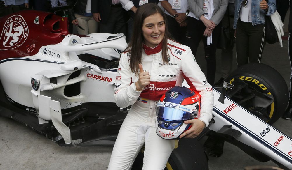 La colombiana de Tatiana Calderón posa al lado del Sauber C37, luego de convertirse en la primera mujer latinoamericana en ponerse al volante de un Fórmula 1. (AP Foto/Marco Ugarte)