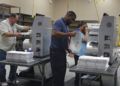Trabajadores electorales colocan boletas en máquinas de conteo, el domingo 11 de noviembre de 2018, en la oficina de la supervisora de las elecciones del condado Broward, en Lauderhill, Florida. (Joe Cavaretta /South Florida Sun-Sentinel vía AP)