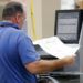 Un empleado de la oficina del Supervisor de Elecciones del condado de Broward pasa boletas por una máquina mientras cuenta votos de la elección legislativa del jueves 8 de noviembre de 2018 en Lauderhill, Florida. (AP Foto/Wilfredo Lee)