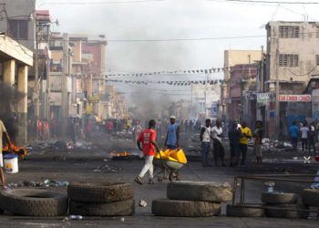 Residentes caminan entre las calles bloqueadas por manifestantes en contra del gobierno en el Boulevard Jean-Jacques Dessalines, una de las principales avenidas comerciales, durante una huelga anti gubernamental el miércoles 21 de noviembre de 2018 en Puerto Príncipe, Haití. Foto: Dieu Nalio Chery / AP.