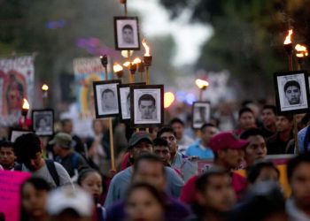 Familiares de los 43 estudiantes desaparecidos participan de una marcha con fotos de sus seres queridos en Ciudad de México, 26 de diciembre de 2015. Foto: Marco Ugarte / AP.