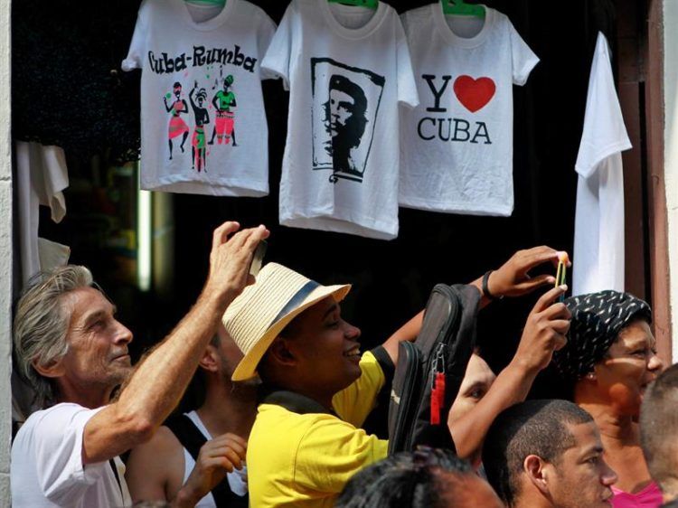 Personas fotografían al presidente Pedro Sánchez mientras recorren calles de La Habana. Foto: Yander Zamora / EFE.