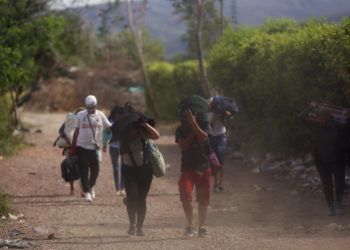 En esta imagen, tomada el 31 de agosto de 2018, venezolanos cruzan ilegalmente la frontera con Colombia, a Villa del Rosario, por una ruta conocida como "trocha". Algunos venezolanos no pueden cruzar por un paso fronterizo oficial porque carecen de documentación oficial, como pasaporte, y emplean carreteras de tierra ilegales gestionadas por hombres armados y vestidos de uniforme. (AP Foto/Ariana Cubillos)