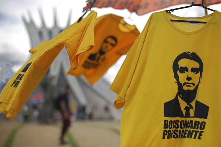 Camisetas con la imagen del presidente electo de Brasil, Jair Bolsonaro, se exhiben para la venta frente a la Catedral de Brasilia, el viernes 28 de diciembre de 2018. (AP Foto/Eraldo Peres)