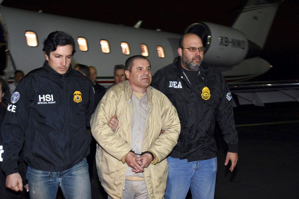 En esta fotografía del 19 de enero de 2017 dos agentes escoltan a Joaquín "El Chapo" Guzmán de un avión hacia una caravana de camionetas en el Aeropuerto MacArthur de Long Island, en Ronkonkoma, Nueva York. (U.S. Law Enforcement vía AP, archivo)