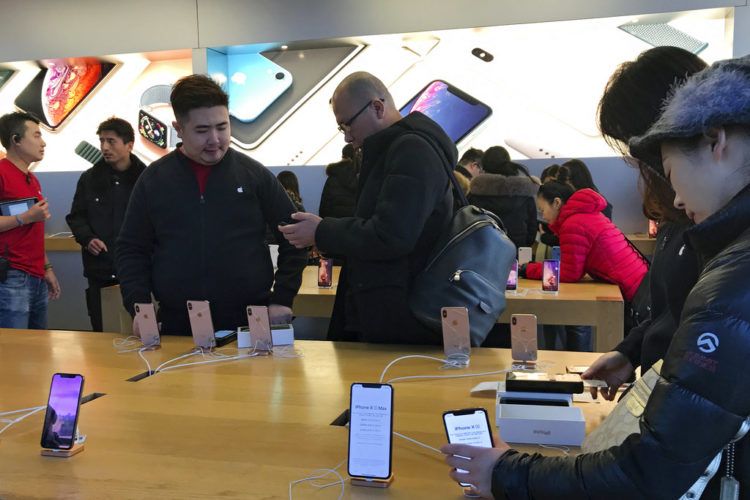 Gente compra el último modelo de iPhone en el Apple Store, Beijing, martes 11 de diciembre de 2018. El jefe de la economía china y el secretario del Tesoro estadounidense discutieron planes para realizar conversaciones sobre la guerra arancelaria. Foto: Andy Wong / AP.