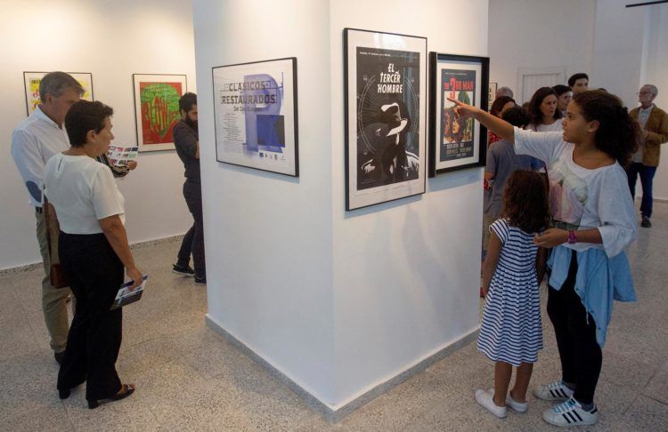 Personas observan los carteles de la exposición "Clásicos restaurados del cine europeo", en la galería 23 y 12 este 8 de diciembre en La Habana Foto: Yander Zamora / EFE.