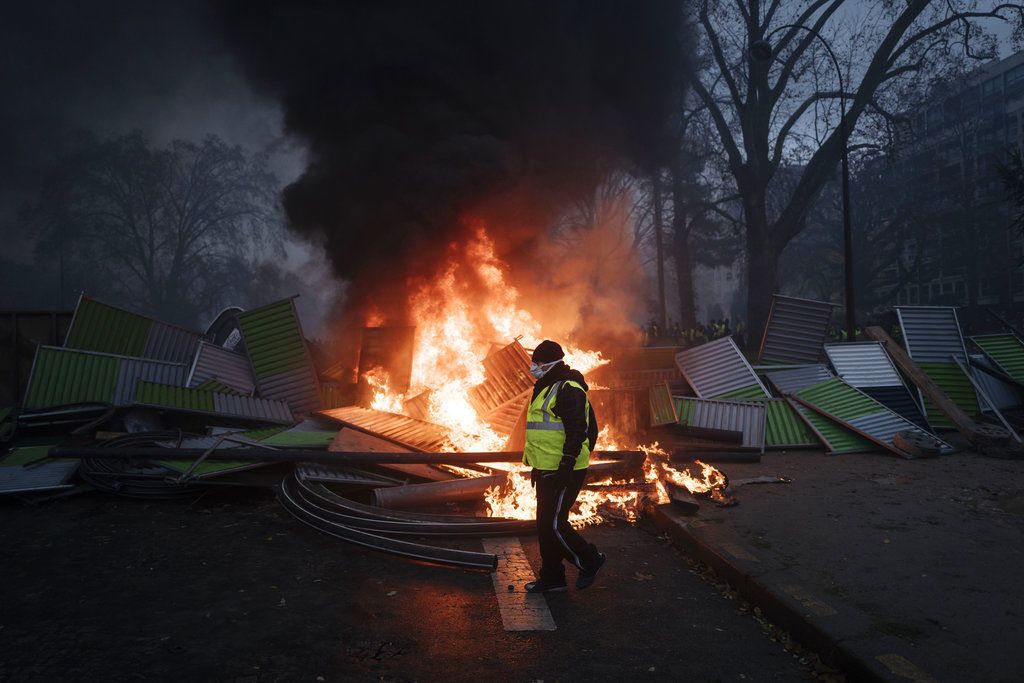 Un manifestante pasa frente a una barricada cerca del Arco del Triunfo en los Campos Elíseos, durante una protesta el sábado 1ro de diciembre de 2018, en París. Foto: Kamil Zihnioglu / AP.