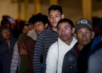 Migrantes hondureños hacen línea para tomar desayuno en un depósito que abrió sus puertas para dar de comer a los migrantes en el centro de Tijuana, México, el martes 18 de diciembre del 2018. Foto: Moisés Castillo / AP.