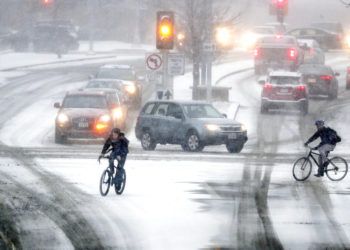 Ciclistas cruzan Park Street en la intersección con University Ave durante una tormenta de nieve, el 18 de enero de 2019 en Madison, Wisconsin. Foto: Steve Apps/Wisconsin State Journal vía AP.