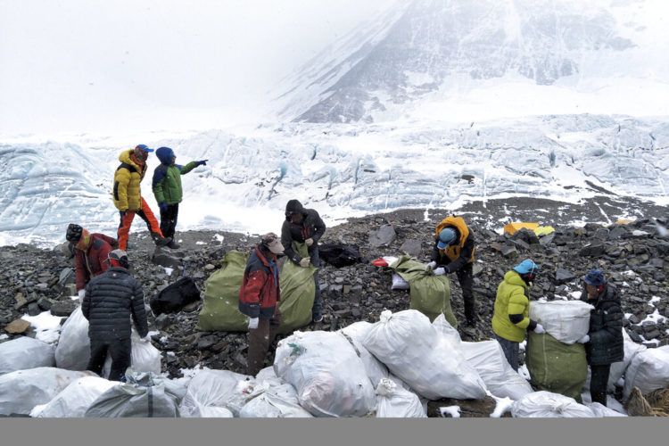 En esta imagen de archivo, tomada el 8 de mayo de 2017 y distribuida por la agencia oficial de noticias de China, Xinhua, un grupo de personas recoge basura en la ladera norte del Monte Qomolangma (el nombre en tibetano para el Everest), en la región autónoma china de Tibet. Foto: Awang Zhaxi / Xinhua vía AP.