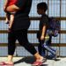 Una madre y sus dos hijos caminan sobre el puente del río Suchiate, parte de un grupo de migrantes centroamericanos que cruzaron la frontera entre Guatemala y México, cerca de Ciudad Hidalgo, estado de Chiapas, México, el jueves 17 de enero de 2019. (AP Foto/Marco Ugarte)
