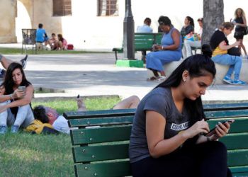 Varias personas usan sus teléfonos móviles en un parque con conexión a Internet mediante wifi pública, el 27 de diciembre de 2018, en La Habana. Foto: Ernesto Mastrascusa / EFE / Archivo.