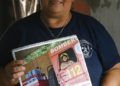 La bombero Natividad Ayala García muestra la página del calendario en la que posa desnuda dentro de un camión del departamento, en Asunción, Paraguay. Foto: Jorge Saenz / AP.