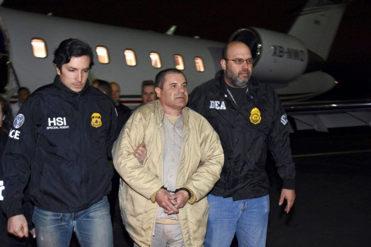 Agentes escoltan al narco mexicano Joaquín "El Chapo" Guzmán, centro, de un avión a una caravana de camionetas en el el aeropuerto MacArthur de Ronkonkoma, Nueva York. Foto: U.S. law enforcement via AP.