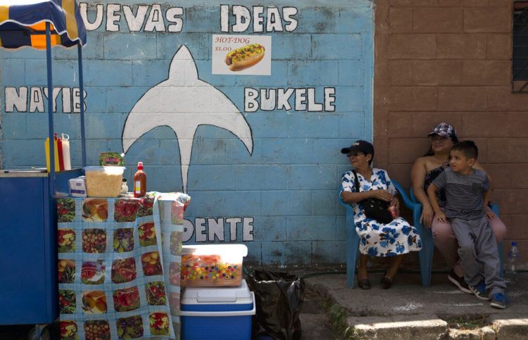 Vecinos se sientan junto a un mural que promueve la candidatura de Nayib Bukele, de la conservadora Gran Alianza para la Unidad Nacional (GANA), a las afueras de San Salvador, El Salvador, el viernes 1 de febrero de 2019. Foto: Moises Castillo / AP.