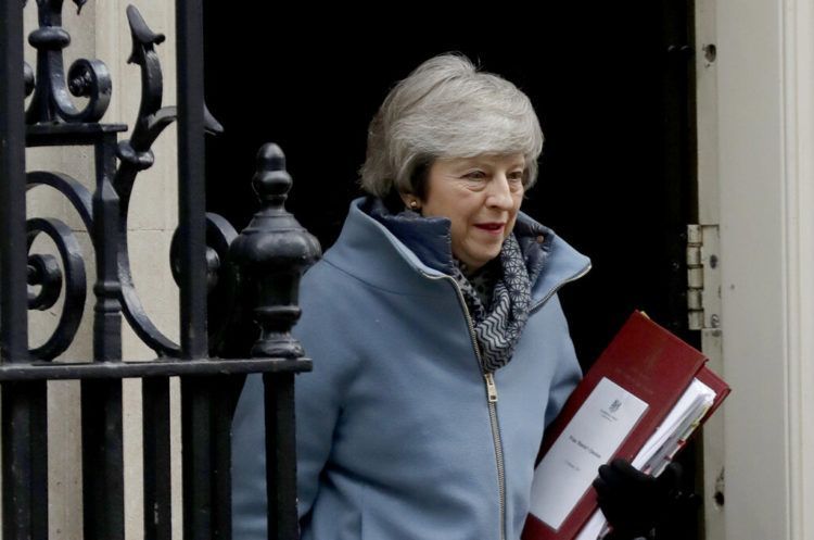 La primera ministra de Gran Bretaña, Theresa May, sale de su residencia oficial en el 10 Downing Street, Londres, para asistir a una sesión de control en el parlamento británico. Foto: Matt Dunham / AP.