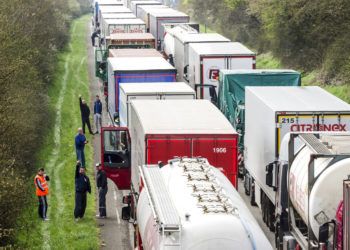 Conductores de camión esperan junto a sus vehículos en una autopista entre Bruselas y Luxemburgo, en Spontin, Bélgica, 6 de abril de 2016. Foto: Geert Vanden Wijngaert / AP.
