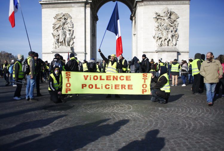 Manifestantes de los chalecos amarillos se reúnen en el Arco del Triunfo con una pancarta que dice “Paren la violencia policial” durante una movilización en París, el sábado 16 de febrero de 2019. Foto: Thibault Camus / AP.