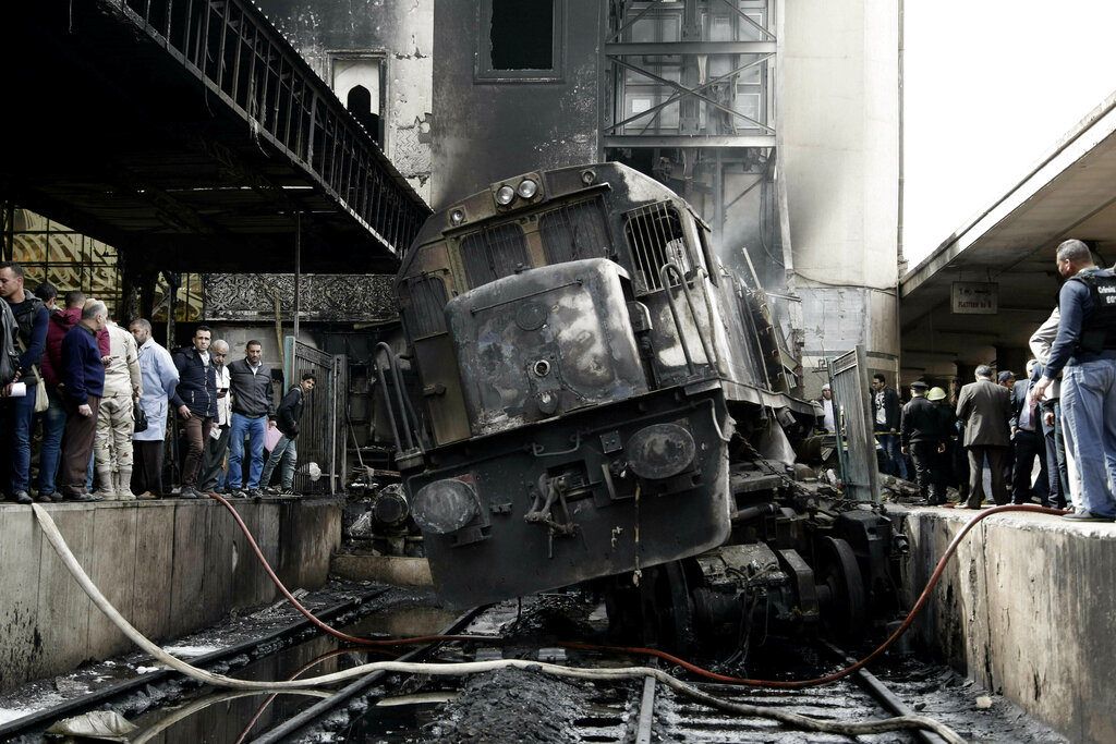 Personas observan un tren dañado tras una colisión y un posterior incendio en el interior de la estación de tren de Ramsés, en El Cairo, Egipto, el 27 de febrero de 2019. Foto: Nariman El-Mofty / AP.