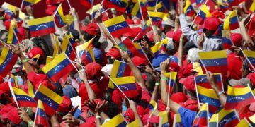 Seguidores del presidente Nicolás Maduro ondean banderas de Venezuela durante un acto en Caracas, Venezuela, el 2 de febrero de 2019. Foto: Ariana Cubillos / AP.