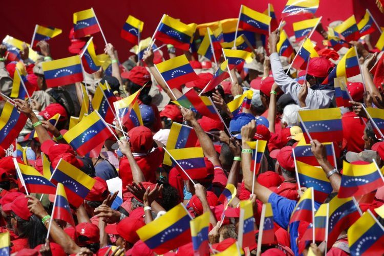 Seguidores del presidente Nicolás Maduro ondean banderas de Venezuela durante un acto en Caracas, Venezuela, el 2 de febrero de 2019. Foto: Ariana Cubillos / AP.
