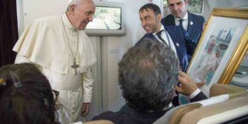 El Papa Francisco recibe un regalo de un periodista a bordo del avión papal cuando viaja de Abu Dabi a Roma el 5 de febrero del 2019. Foto: Luca Zennaro / Pool vía AP.