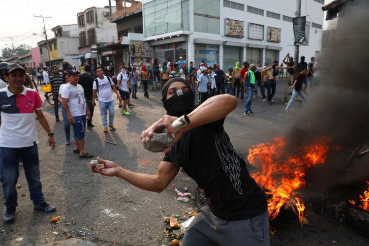 Un manifestante arroja piedras durante enfrentamientos con la Guardia Nacional Bolivariana en Ureña, Venezuela, cerca de la frontera con Colombia, el sábado 23 de febrero de 2019. Foto: Rodrigo Abd / AP.