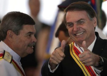 En esta imagen, tomada el 28 de marzo de 2019, el presidente de Brasil, Jair Bolsonaro, levanta los pulgares junto al almirante Marcus Vinicius Oliveira dos Santos, presidente de la Suprema Corte Militar, que le entregó a Bolsonaro la Orden Judicial al Mérito Militar, en Brasilia, Brasil. Bolsonaro, un excapitán del ejército que dijo añorar la dictadura (1964-1985), pidió el 25 de marzo al Ministerio de Defensa que organice las "debidas conmemoraciones" por el aniversario del golpe de Estado militar de 1964 el 31 de marzo. (AP Foto/Eraldo Peres)