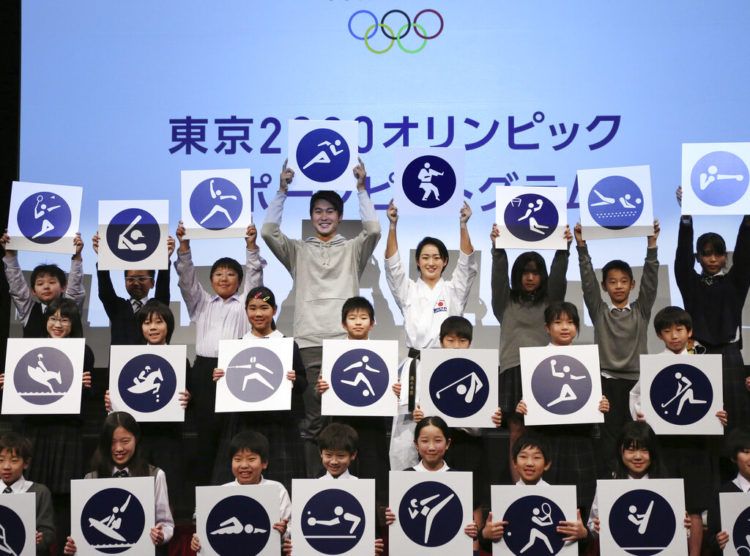 Kiyo Shimizu, (centro a la derecha) posan junto a estudiantes con los pictogramas de los Juegos Olímpicos de Tokio 2020 durante un acto para celebrar la cuenta regresiva de 500 días para las justas, el martes 12 de marzo de 2019. (AP Foto/Koji Sasahara)