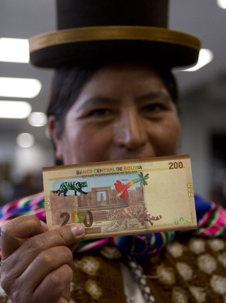 Una mujer sostiene el nuevo billete de 200 bolivianos luego de una ceremonia para presentar un conjunto de nuevos billetes en el palacio de gobierno de La Paz, el martes 23 de abril de 2019. (AP Foto / Juan Karita)
