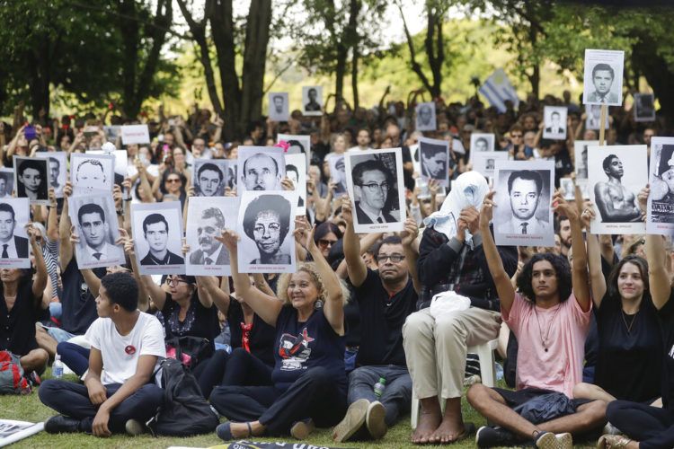 Manifestantes muestras fotografías de personas que fueron asesinadas durante la última dictadura brasileña, en una protesta en Sao Paulo, Brasil, el domingo 31 de marzo de 2019. Foto: Andre Penner / AP.