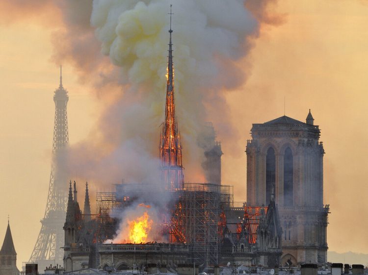 En esta fotografía del lunes 15 de abril de 2019 se muestra la Torre Eiffel en el fondo y una columna de humo y llamas que salen de un incendio en la catedral de Notre Dame en París. Foto: Thierry Mallet/AP